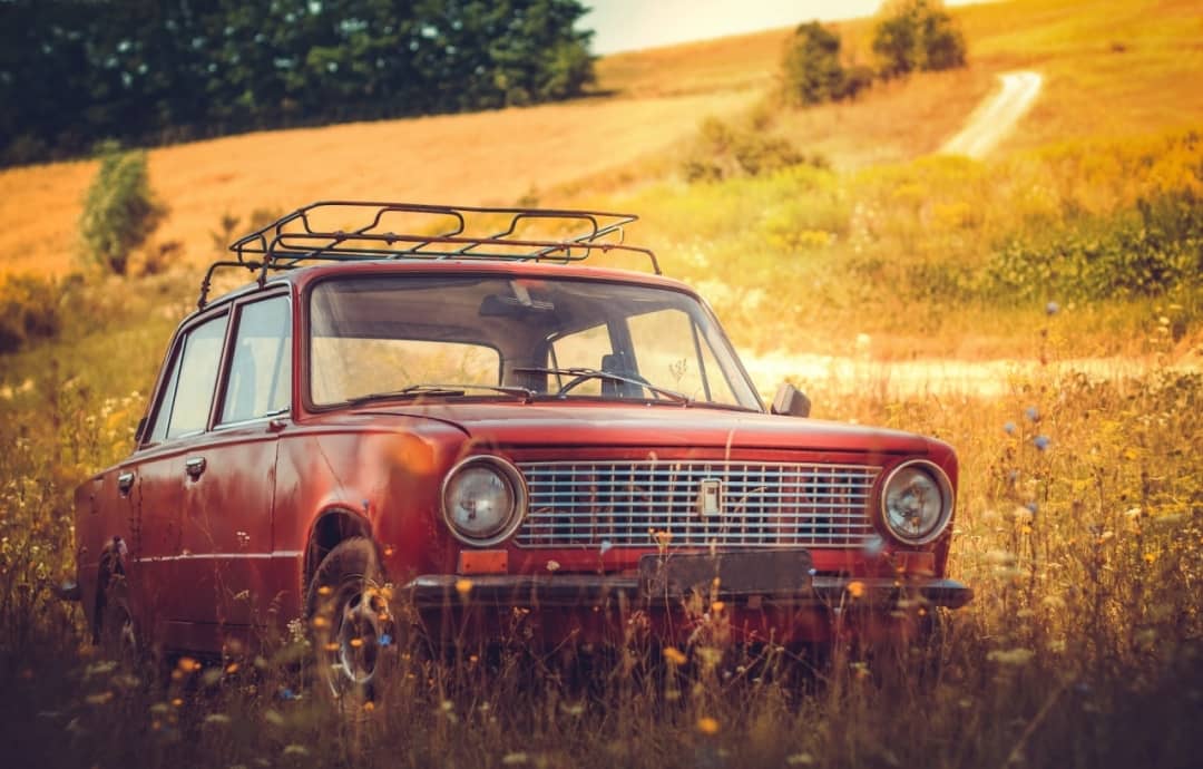 vieille voiture rouge dans un champ